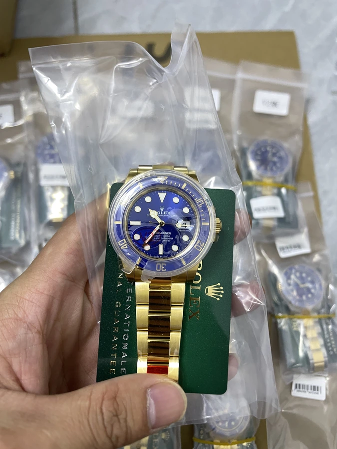 Blue dial watch with a two-tone gold and silver bracelet, photographed in hand.